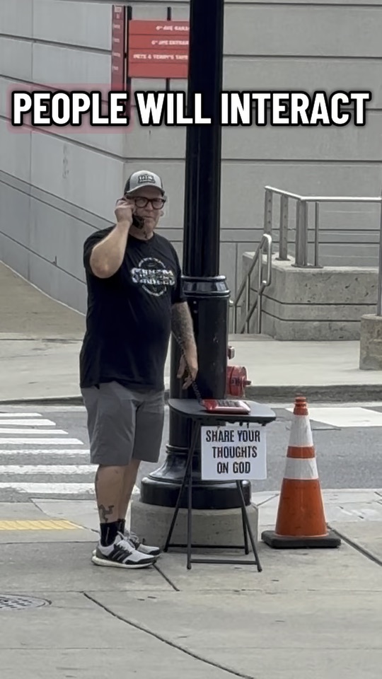 The PrayPhone table with its sign on a downtown corner